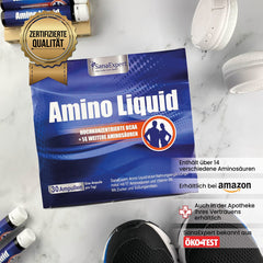 Packung von Amino Liquid auf einer hellen Oberfläche, flankiert von einer Sportwasserflasche und Amino Liquid Ampullen, mit Qualitätszertifikat im Bild.