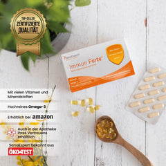 SanaExpert Immun Forte Packung präsentiert auf einem Tisch neben einer Pflanze und Kapseln, betont die zertifizierte Qualität und natürlichen Zutaten.