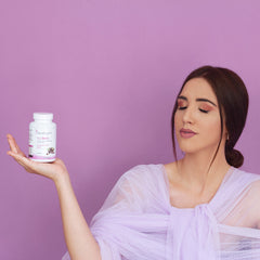 Eine Frau in lila Kleidung balanciert sorgfältig eine Flasche SanaExpert Acai Berry Nahrungsergänzungsmittel auf ihrer Handfläche.