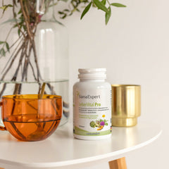 Tischansicht von LeberVital Pro Flasche neben einer orangefarbenen Glasvase und goldenem Becher, elegantes Ambiente.