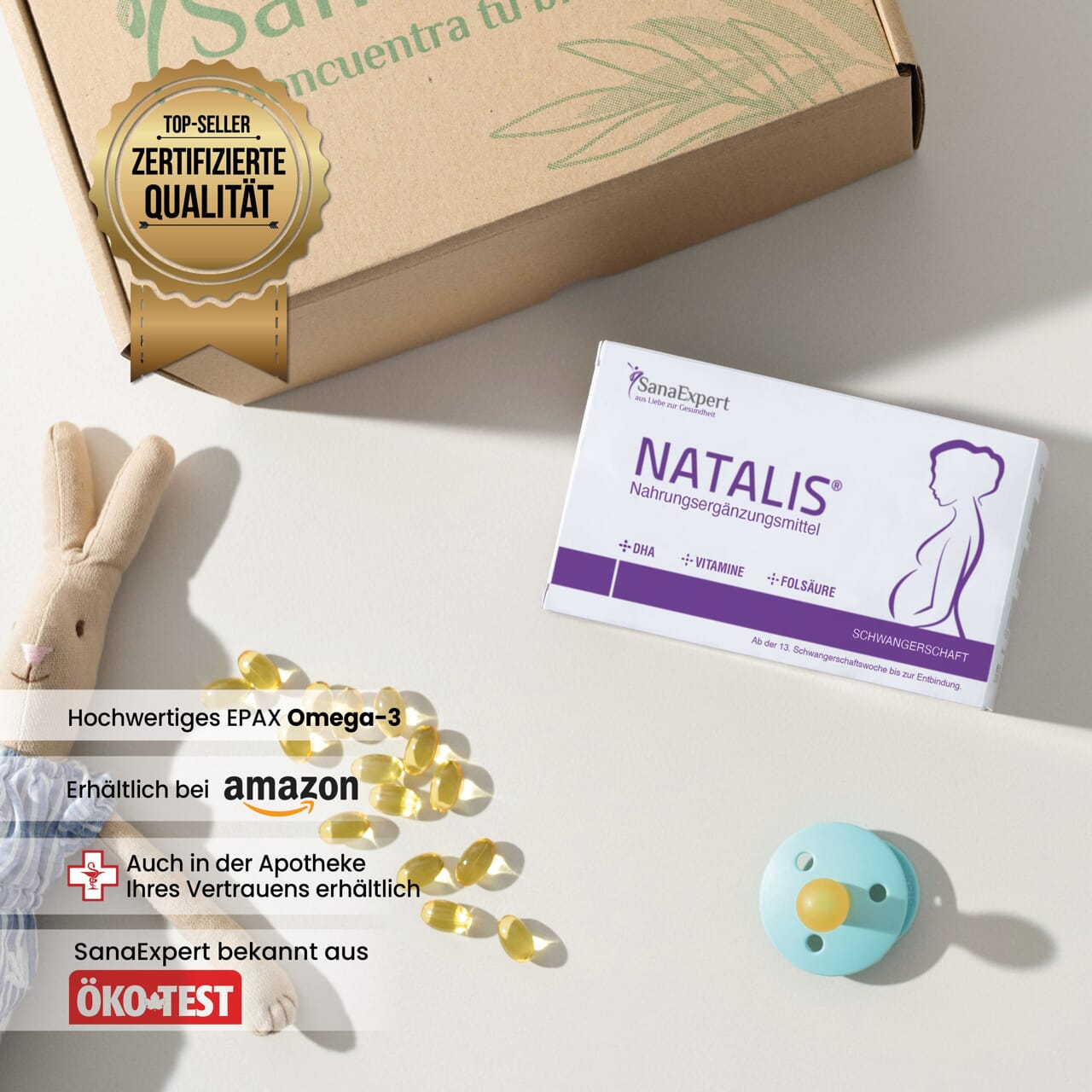 Natalis Verpackung neben einem Qualitätszertifikat und kindlicher Deko, inklusive Holzspielzeug und Schnuller.